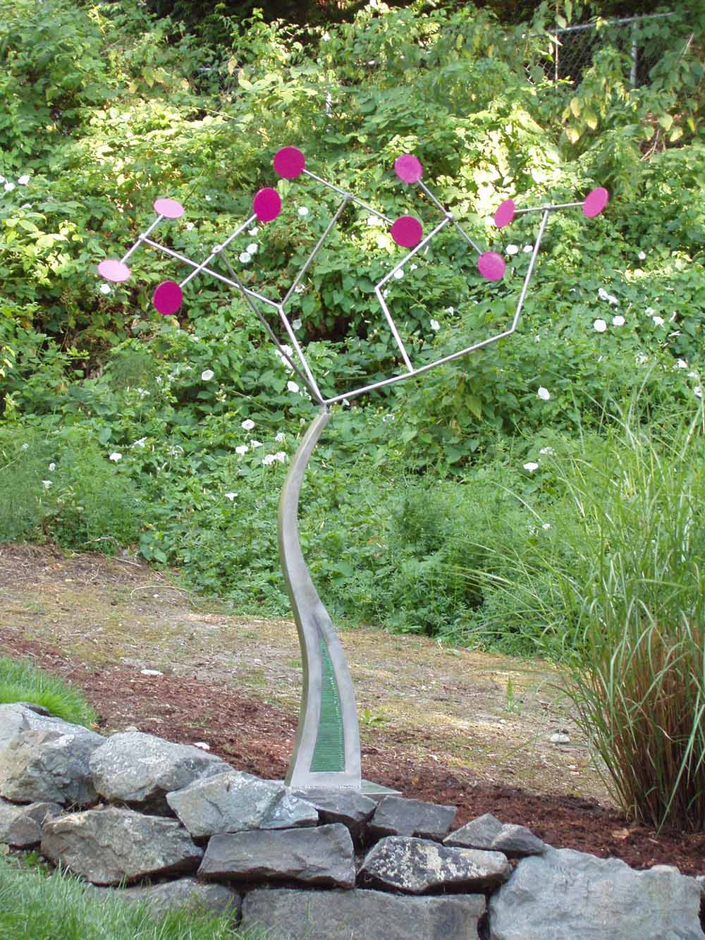 small tree shaped sculpture with magenta petals and leaves